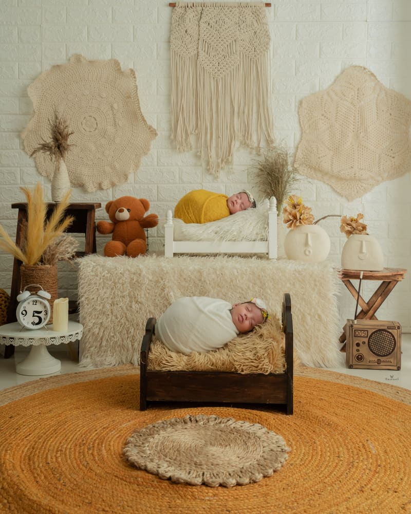 A newborn asleep on a cream set with macramé and a jute rug